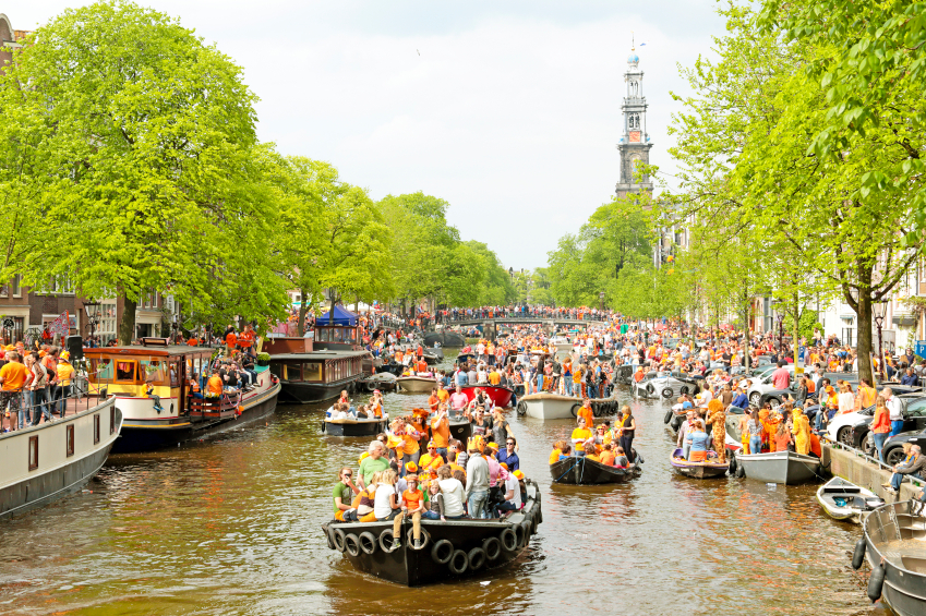 AMSTERDAM - APRIL 26: Amsterdam canals full of boats and people in orange at the Prinsengracht during the celebration of kings day on April 26, 2014 in Amsterdam, The Netherlands