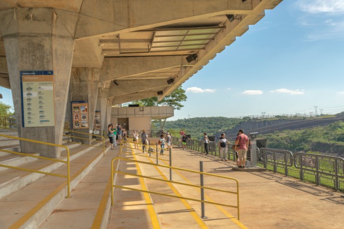 FOZ DO IGUAZU, BRAZIL, APRIL - 2015 - Group of tourist crossing the installations of the Itaipu dam in the brazilian border.