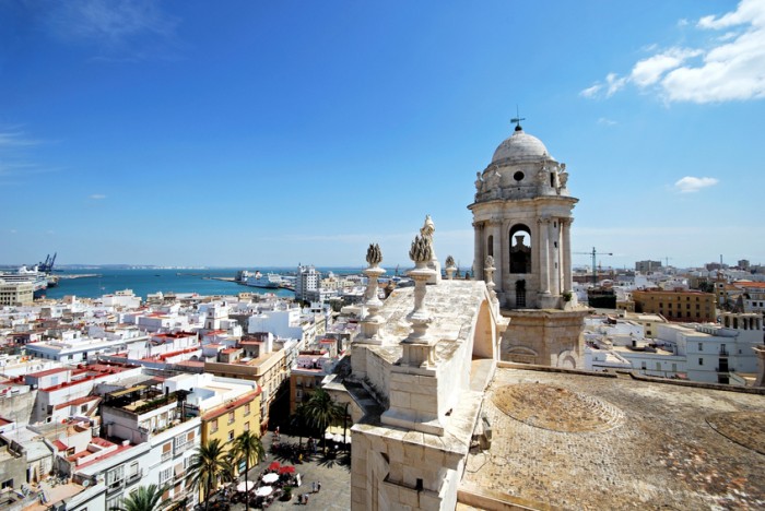 Cadiz, Spain - September 8, 2008: Eastern bell tower and rooftop statues on the Cathedral with views towards the port and tourists in the square, Cadiz, Cadiz Province, Andalusia, Spain, Western Europe.
