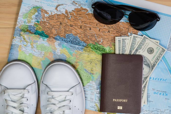 shoes, passport, cash, sunglasses on a map