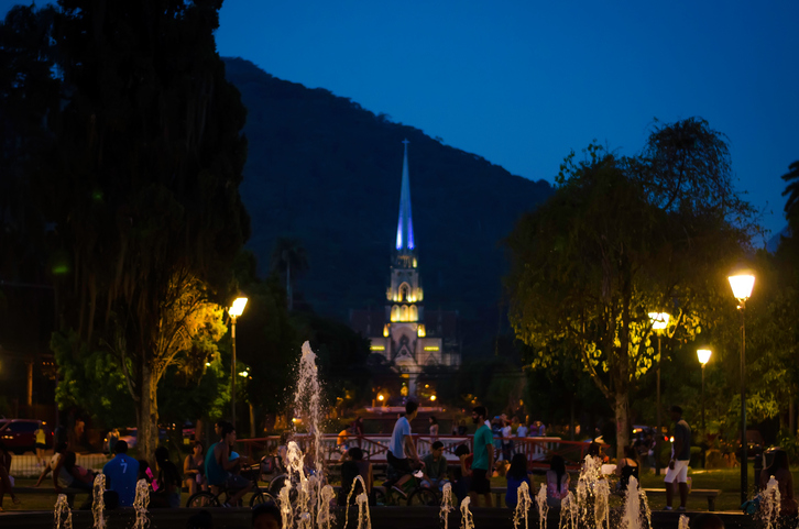 Petrópolis, Brazil- January 17, 2015: Metropolitan Cathedral  of Petropolis, Rio de Janeiro, Brazil. View from the Square of Freedom, where there is a fountain, and several people relaxing and having fun in an early dusk. The cathedral began to be built in 1884 in neo-Gothic style, and its patron is St. Peter of Alcantara.