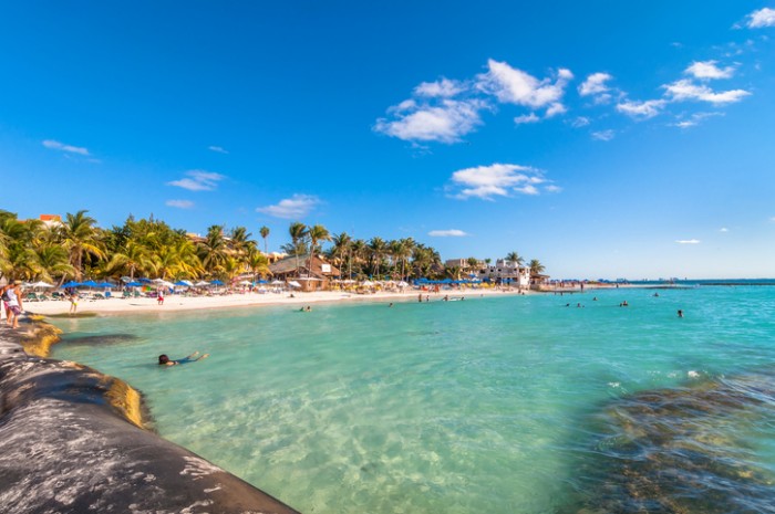 Isla Mujeres, Mexico - April 21, 2014: tourists enjoy tropical sea on famous Playa del Norte beach in Isla Mujeres, Mexico. The island is located 8 miles northeast of Canc?n in the Caribbean Sea.