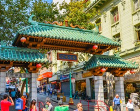 San Francisco, CA - Aug. 15, 2015: Tourists under Dragon Gate, the landmark gateway arch marking the entrance to the city's iconic Chinatown neighborhood.
