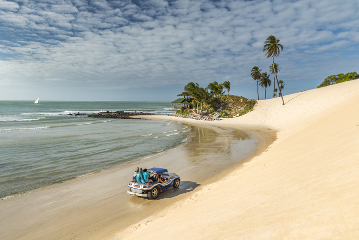 Natal, Rio Grande do Norte, Brazil. 01st September 2017. One buggy (bugre) driving offroad near the sea water at the beach of Genipabu (also known as Jenipabu). Local popular trourist attraction, riding sand dunes on a car is fun.