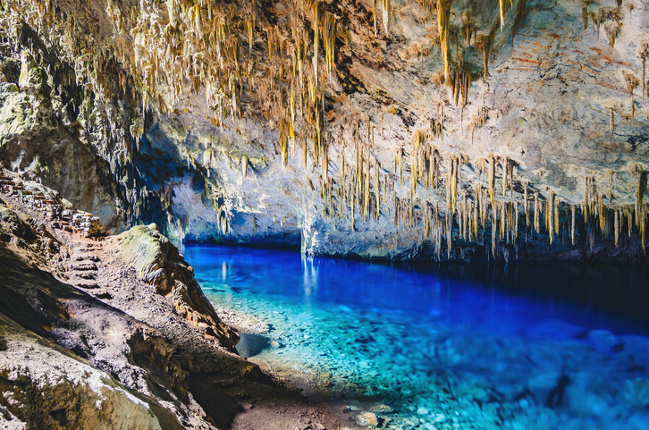 Bonito, Brazil - November 19, 2017: Inside the grotto of Lago Azul, a grotto with a lake with transparente vibrant blue water. Stalactites and stones. A natural tourist attraction of Bonito.