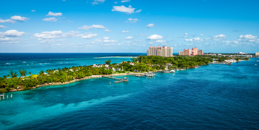 Bright and vibrant panoramic image with Paradise Island and palm trees close at the cruise port of Nassau in the Bahamas. Blue sky and some white clouds. Wide image.