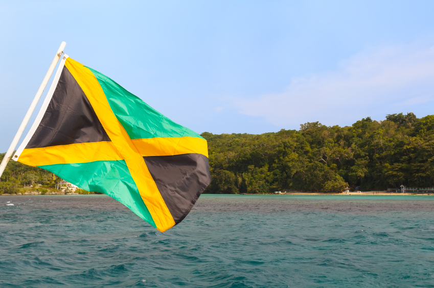 Jamaica flag waving sea beach sky. Selective focus on flag