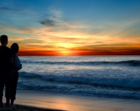 Young couple enjoying a sunset on the beach