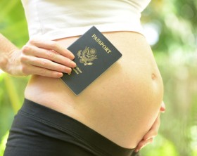 pregnant woman holding passport before she travels during pregnancy