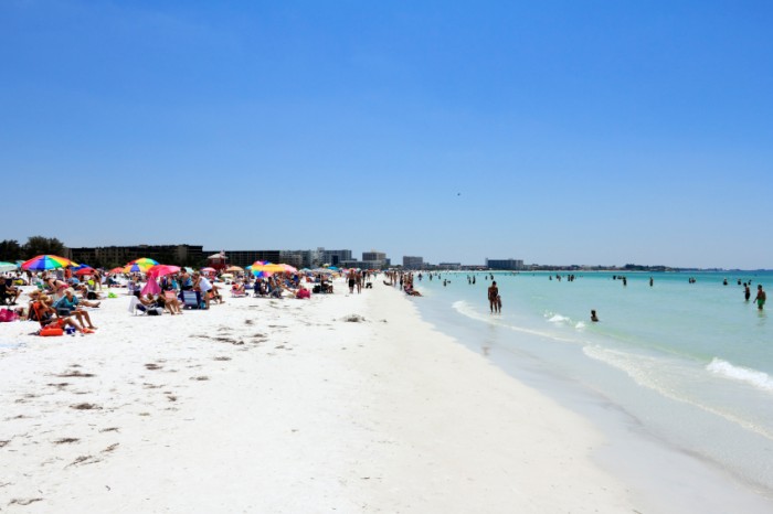 SIESTA KEY, FLORIDA - MAY 9, 2013: Many people relaxing on one of the top ten beaches in the United States, world renowned for its beauty and sand made of fine 99% pure white quartz that stays cool.