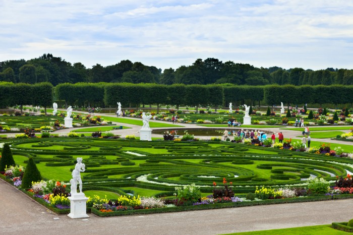 "Hannover, Germany. August 5, 2012: These unique garden grounds, laid out in a baroque style, are one of the most famous attractions in Hannover. Grober Garden was sculpted in 1699 on the request of princess Sophie. Pictured are some of the many tourists visiting the place that day."