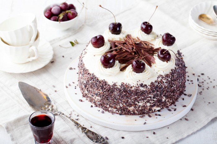 Black forest cake, Schwarzwald pie, dark chocolate and cherry dessert on a white wooden background