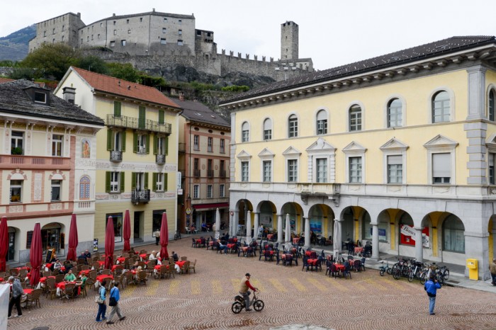 Bellinzona, Switzerland - 15 October 2014: People walking and sitting on restaurants at Collegiata square of Bellinzona on Switzerland