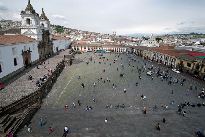 Quito, Ecuador - November 15, 2014: The huge Plaza de San Francisco is dominated by the Basilica San Francisco, a massive religious complex, the largest in Latin America. , seen from above,people gather in the square in the early morning with old Quito in the background