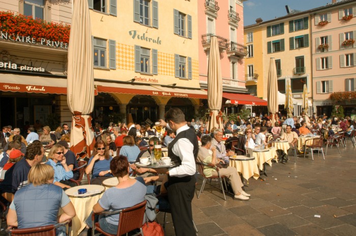 Lugano, Switzerland - 7 October 2002: People eating and drinking at restaurants of the central square of Lugano on the italian part of Switzerland