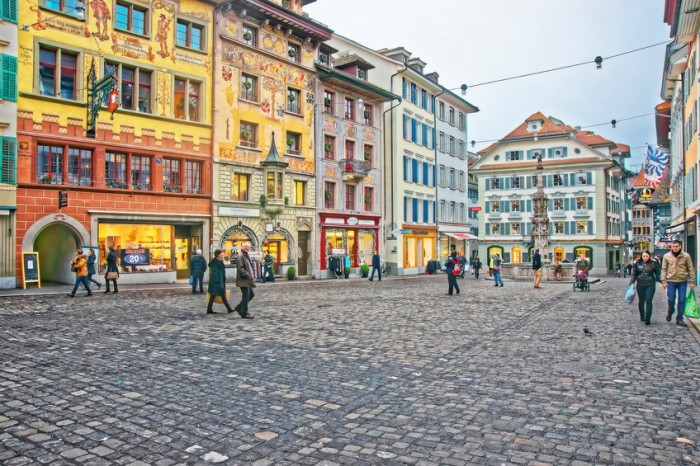 Lucerne, Switzerland  - January 4, 2014: People on Muhlenplatz in Lucerne Old Town with cobbled streets and beautiful medieval houses. This area served as a venue for trade fairs since the 16th century