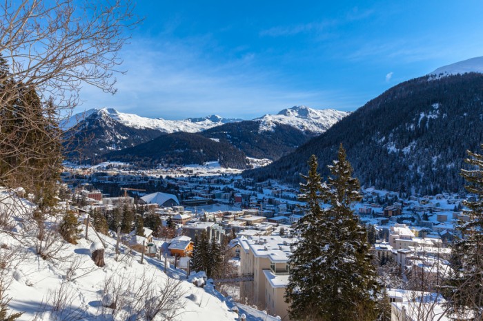 Aerial view of Davos in Winter with snow covered roofs and the Alps, Canton of Grisons, Switzerland.
