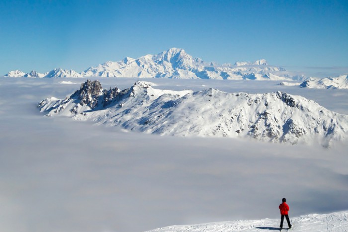 Skier looking at the Mont Blanc over a sea of clouds, the Alps, France