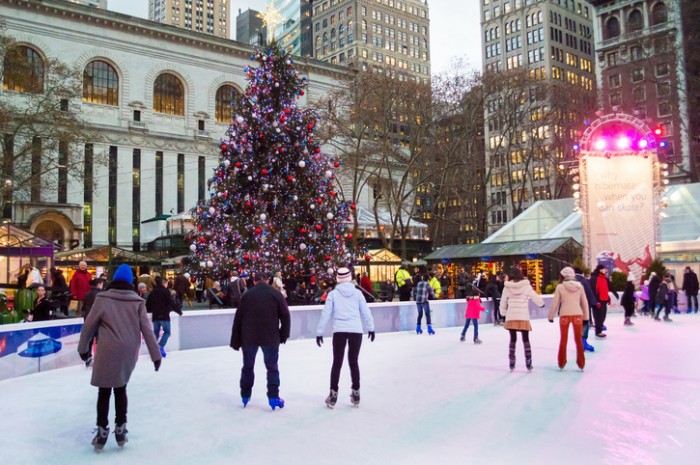 New York, NY, USA - December 10,2013: Ice skaters and tourists near the Christmas tree in Bryant Park on December 10, 2013 in Manhattan.