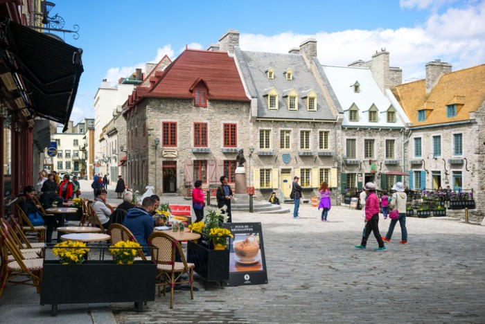 Quebec, Canada - May 5, 2014:  Tourists walking and seated in an open air bar of Royal square in the old town