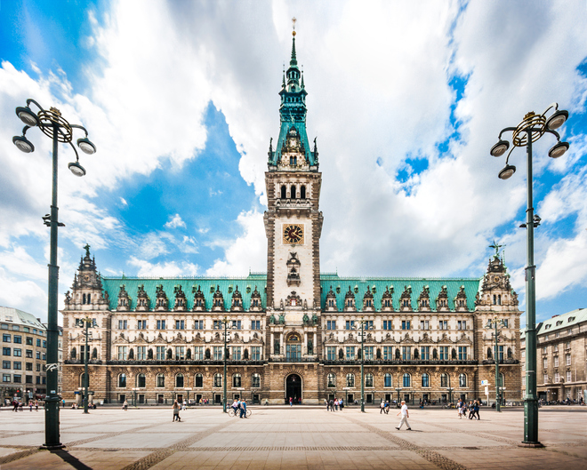 Beautiful view of famous Hamburg town hall with dramatic clouds and blue sky at market square near lake Binnenalster in Altstadt quarter, Hamburg, Germany.