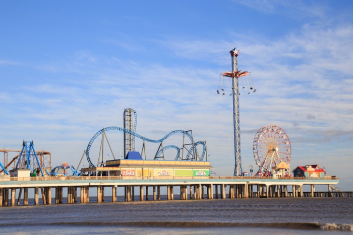 Galveston, USA - January 10, 2016: Historic Pleasure Pier amusement park and beach on the Gulf of Mexico coast in Galveston, Texas.