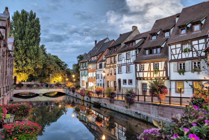 Colorful traditional french houses on the side of river Lauch at the evening in Colmar, France