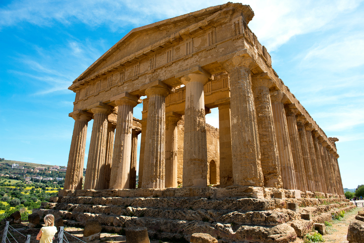 Agrigentp, Sicily, Italy - May 1, 2015: The ruins of The Temple of Concorde, Valley of Temples, Agrigento, Sicily, Italy with one person in the foreground