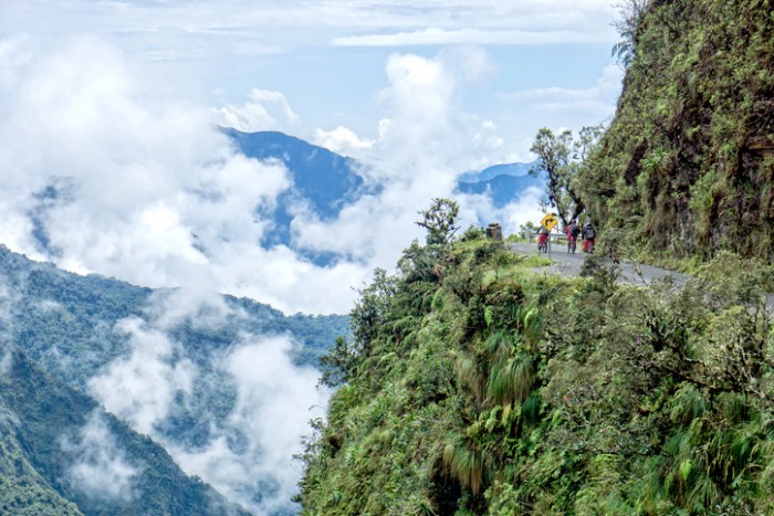 Mountain bikers riding the famous downhill trail "Road of death" in Bolivia