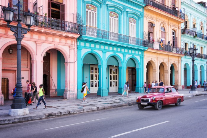 Havana, Cuba - April 18, 2016: Classic vintage car and colorful colonial buildings in the main street of Old Havana