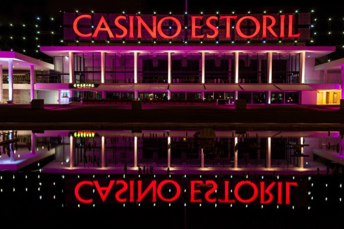 Estoril, Portugal - July 4, 2012: Facade of Estoril Casino illuminated at night and reflected in a pond