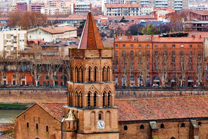 Saint Nicolas V-th century church on Toulouse city center and Garonne river background, France