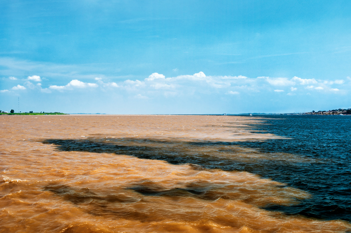 The Meeting of Waters is the confluence between the Rio Negro, a river with dark full of tannins water, and the sandy-colored Amazon River or Rio Solimões, as it is known the upper section of the Amazon in Brazil. For 6 km (3.7 mi) the river's waters run side by side without mixing. The same also happens near Santarém, Pará with the Amazon and Tapajós rivers..This phenomenon is due to the differences in temperature, speed and water density of the two rivers. The Rio Negro flows at near 2 km per hour at a temperature of 28°C, while the Rio Solimões flows between 4 to 6 km per hour a temperature of 22°C.