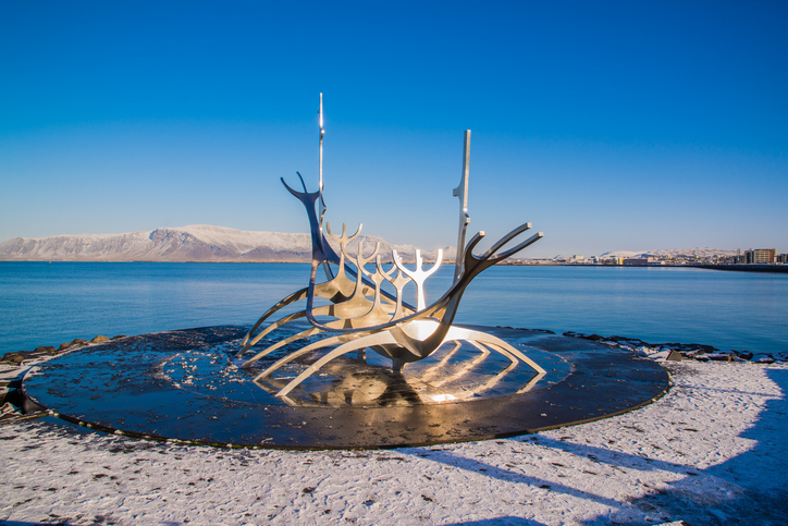 REYKJAVIK, ICELAND - CIRCA MARCH 2013 - Sculpture of Sun Voyager (Solfar) in Reykjavik, Iceland designed by Jon Gunnar Arnason, at the clear spring evening with sea and mountains in background;