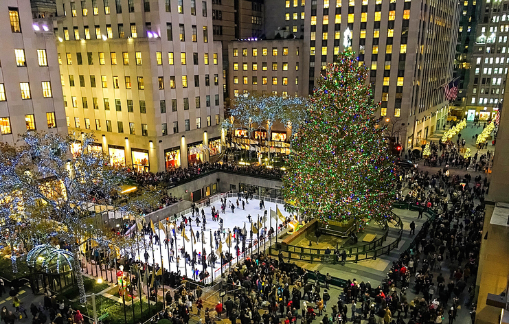 A scenic overview of the hustle and bustle of the holidays at night beneath the magnificent tree in Rockefeller Center.