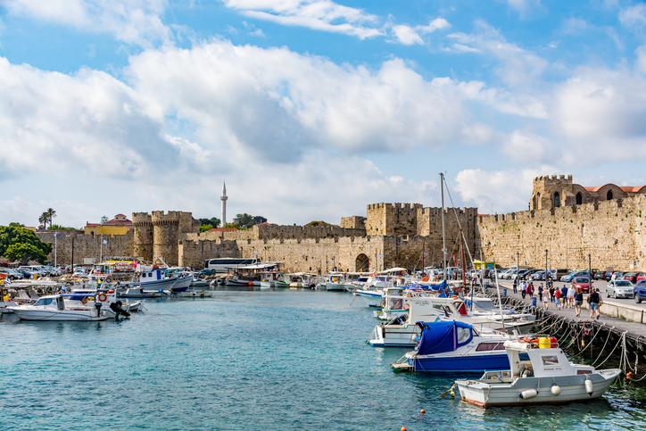 Rhodes, Greece - 17 April, 2017: Panoramic view of the fishing harbor and old town walls in Rhodes