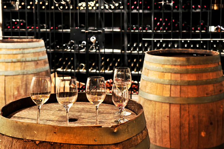 Row of wine glasses on barrel in winery cellar