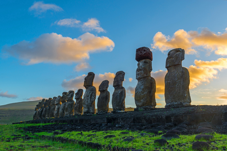 The sun shining at sunrise on the fifteen Moai of the Easter Island in the Pacific Ocean, Chile.