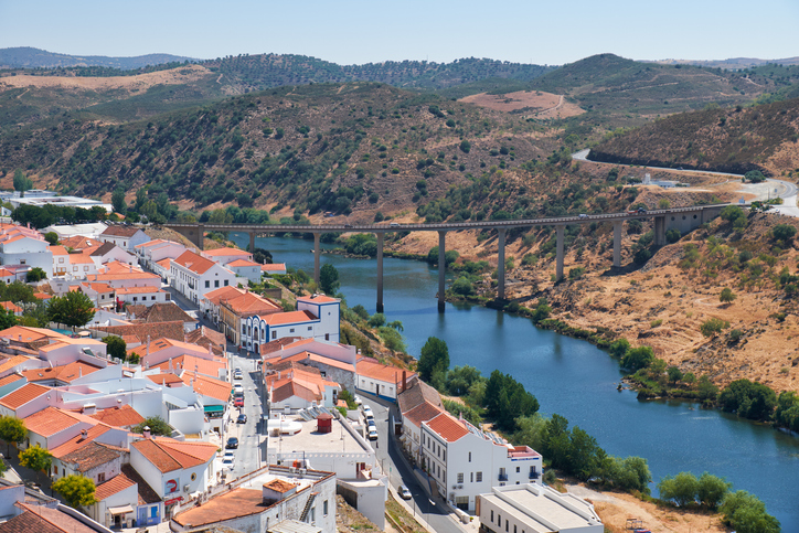 MERTOLA, PORTUGAL - JUNE 30, 2016:   The view of Mertola city on the riverside of Guadiana with the bridge over the river on the background. Baixo Alentejo. Portugal