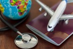 ASSIST CARD oferece até seis meses de seguro grátis Global Healthcare and travel insurance concept. Passport Stethoscope, airplane and globe on wooden table