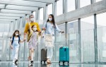 Aceitar passageiros vacinados deve ser prática global para a reabertura das fronteiras Family face masks at the airport.