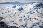 A line of tourists trekking on glacier at the Perito Moreno Glacier, El Calafate, Patagonia, Argentina, on a sunny but cloudy day.