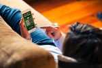 Ideias criativas para se divertir durante uma longa viagem Mobile phone with sports betting website app in the screen.