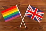 VisitBritain lança guia para inspirar viagens LGBTQIA+ à Grã-Bretanha Rainbow flag LGBT and flag of Great Britain on brown wood planks background. LGBT Pride Month. LGBTQ. LGBTQIA. Close Up. Top view