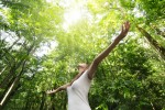 Turismo sustentável: como fazer com que sua viagem melhore o mundo Young woman enjoying nature in green forest
