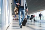 Mais de 150 países estão com fronteiras abertas para viajantes do Brasil Man with shoulder bag and hand luggage walking in airport terminal