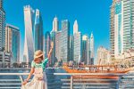 12 destinos para cada signo do horóscopo chinês conhecer em 2022 Cheerful asian traveler girl walking on a promenade in Dubai Marina district. Travel destinations and tourist lifestyle in UAE