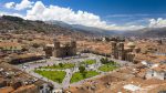 Aerial view of the Cusco's main plaza with crowd of people watching the flag raising act.