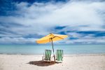beach-parasol-and-green-beach-chairs-on-a-shore