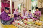 Muslim family saying prayers before meal